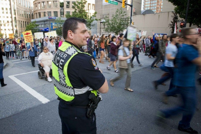 Vancouver Police officer watches demonstrators protest on the streets 
