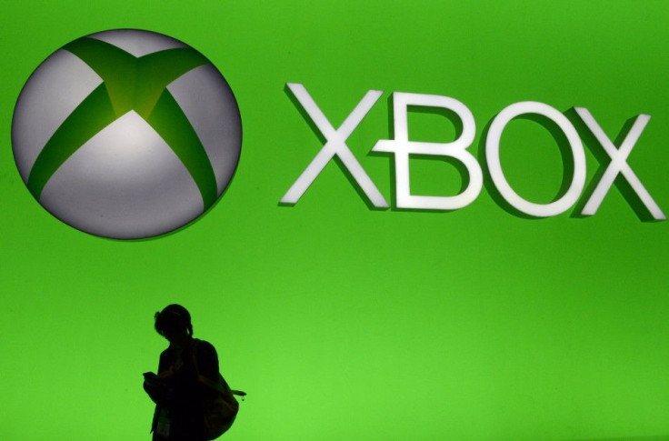 An Attendee Uses Her Smartphone In Front Of A Fiant Microsoft Xbox Sign At The 2014 Electronic Entertainment Expo, Known as E3, in Los Angeles