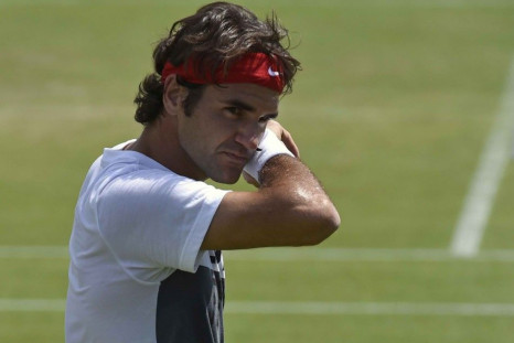 Roger Federer of Switzerland wipes his face during a training session ahead of the Wimbledon Tennis Championships in London June 22, 2014.