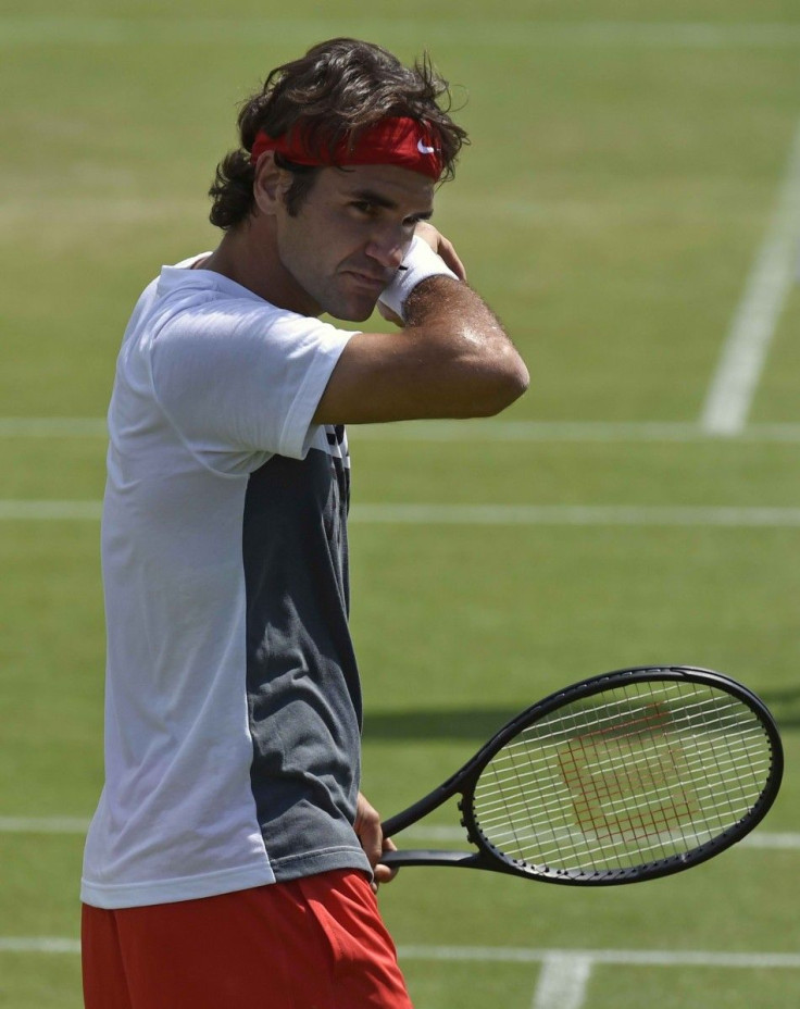 Roger Federer of Switzerland wipes his face during a training session ahead of the Wimbledon Tennis Championships in London June 22, 2014.