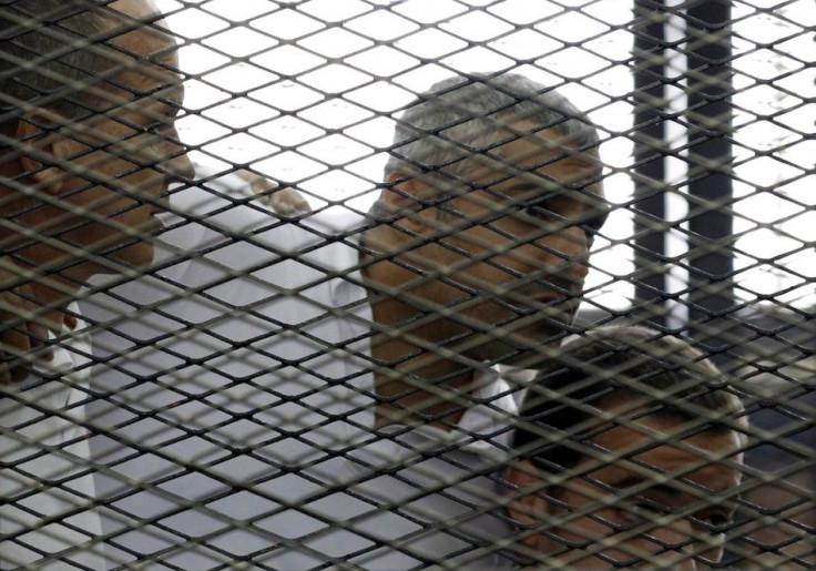 Peter Greste, Mohamed Fahmy and Baher Mohamed listen to a ruling at a court in Cairo