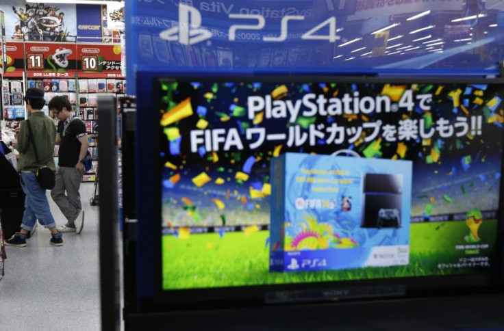 Shoppers browse for video games near a poster advertising a FIFA soccer video game played on Sony Corp's PlayStation 4 console, at an electronics retail store in Tokyo June 10, 2014.