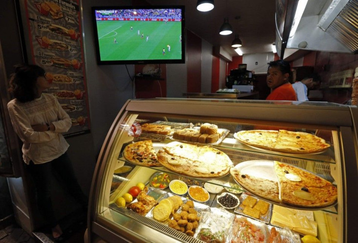 A customer watches a live broadcast of the 2014 World Cup match between Ecuador and France, in Marseille