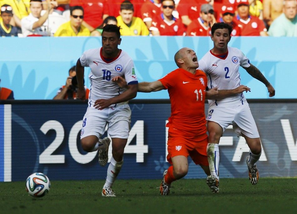 Arjen Robben of the Netherlands C falls between Chiles Gonzalo Jara and Eugenio Mena R