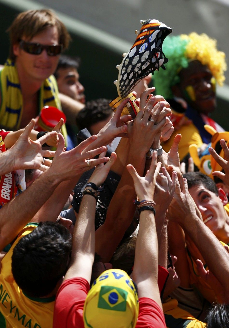 Fans try to grab a boot thrown to them by Spains goalkeeper Iker Casillas