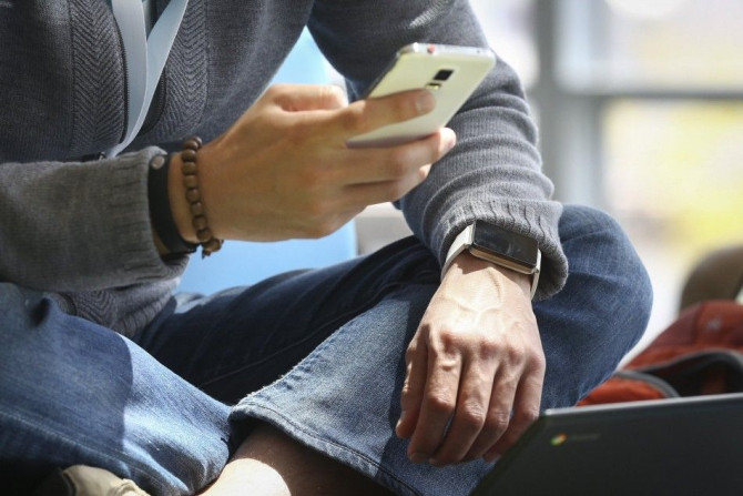 A Google Employee Wears An Android Wear Smart Watch While Using His Phone.