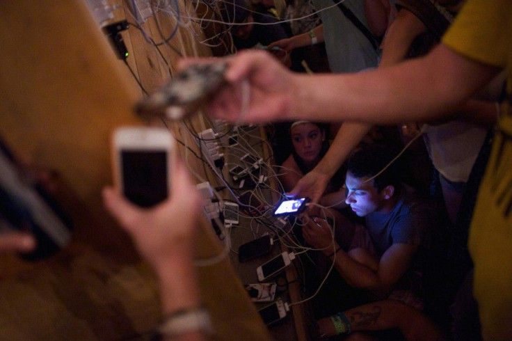 Jake Snyder (bottom R) and a large gathering of concert goers charge their mobile phones during the Firefly Music Festival in Dover June 21, 2014.