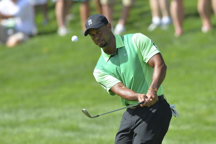 Jun 26, 2014; Bethesda, MD, USA; Tiger Woods chips onto the green on the 15th hole during the first round of the Quicken Loans National golf tournament at Congressional Country Club - Blue Course.