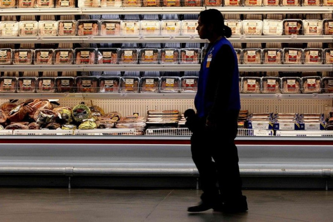 A employee walks by a meat cooler in the grocery section of a Sam's Club during a media tour in Bentonville, Arkansas June 5, 2014. 