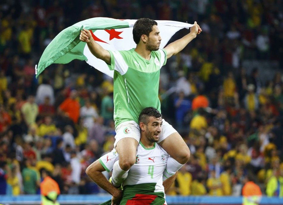 Algerias Essaid Belkalem carries teammate Abdelmoumene Djabou