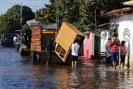 Paraguayans remove their belongings from their flooded houses near the Paraguay river in Asuncion, June 9, 2014. The National Emergency Secretary estimates that about 20,000 families are affected by the flooding of the country's two main rivers, the Parag