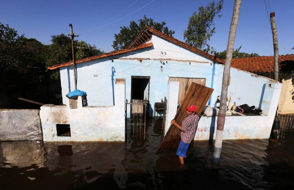 A man carries a door to prevent it from being destroyed by floodwaters near the Paraguay river in Asuncion, June 9, 2014 .The National Emergency Secretary estimates that about 20,000 families are affected by the flooding of the countrys two main rivers, 