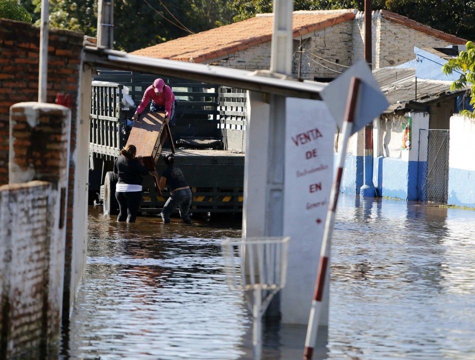 Paraguayans load their belonging on to a truck away from their flooded house near the Paraguay river in Asuncion, June 9, 2014. The National Emergency Secretary estimates that about 20,000 families are affected by the flooding of the countrys two main ri