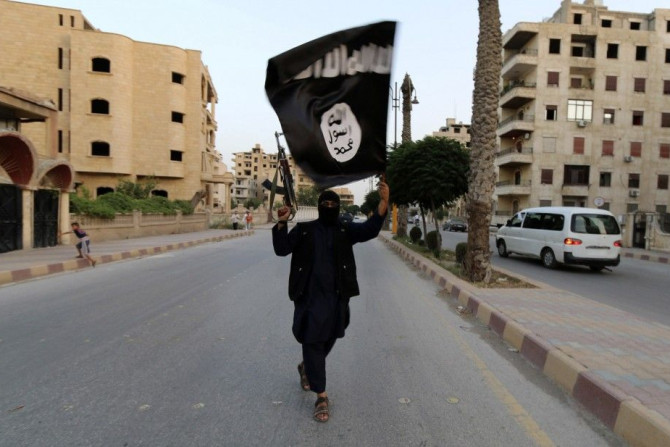 A Member Loyal To The Islamic State In Iraq And The Levant (ISIL) Waves An ISIL Flag In Raqqa.