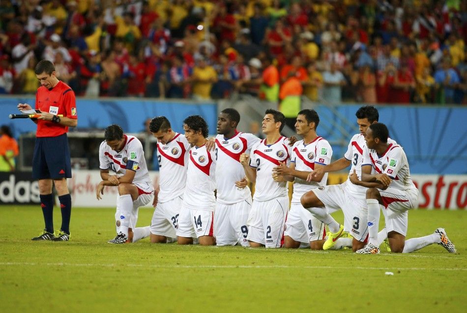 Costa Ricas players watch the penalty shootout 