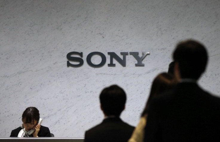 A RECEPTIONIST SPEAKS ON A PHONE UNDER A SONY CORP LOGO AT THE COMPANY'S HEADQUARTERS IN TOKYO