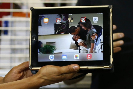 U.S. President Obama holds up his iPad during a visit to TechShop in Pittsburgh