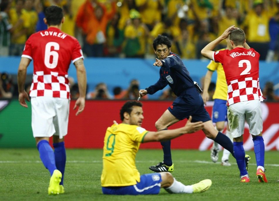 Referee Yuichi Nishimura C of Japan gestures for a penalty during the 2014 World Cup opening match between Brazil and Croatia at the Corinthians arena in Sao Paulo June 12, 2014.