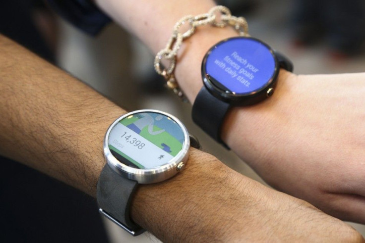 Google employees show off the two different colors of the Moto smartwatch at the Google I/O developers conference on June 25, 2014.