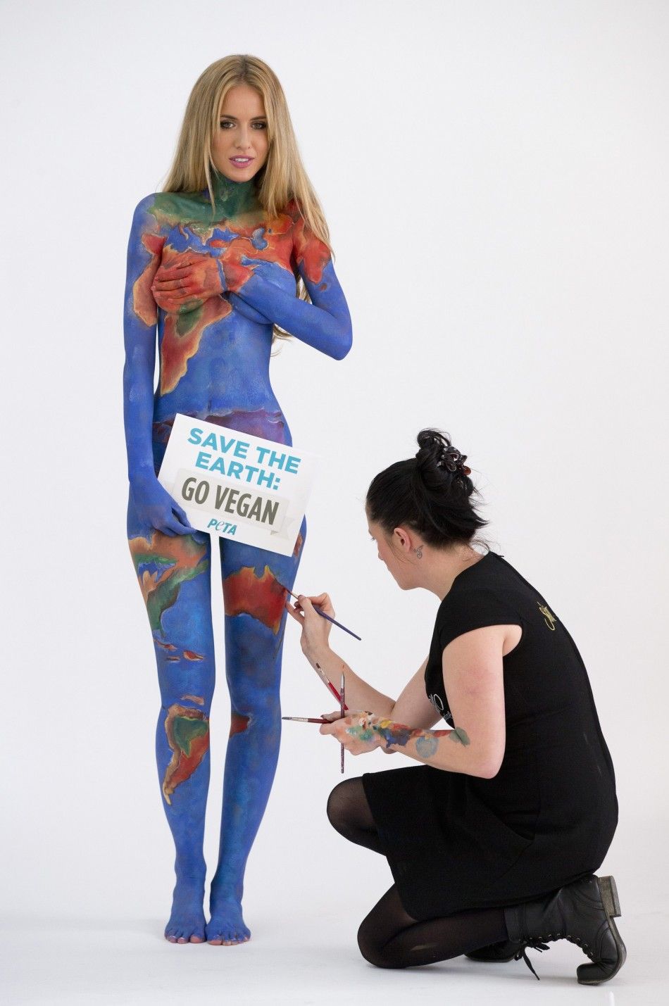 Artist Jade Little touches up body paint on model Renee Somerfield