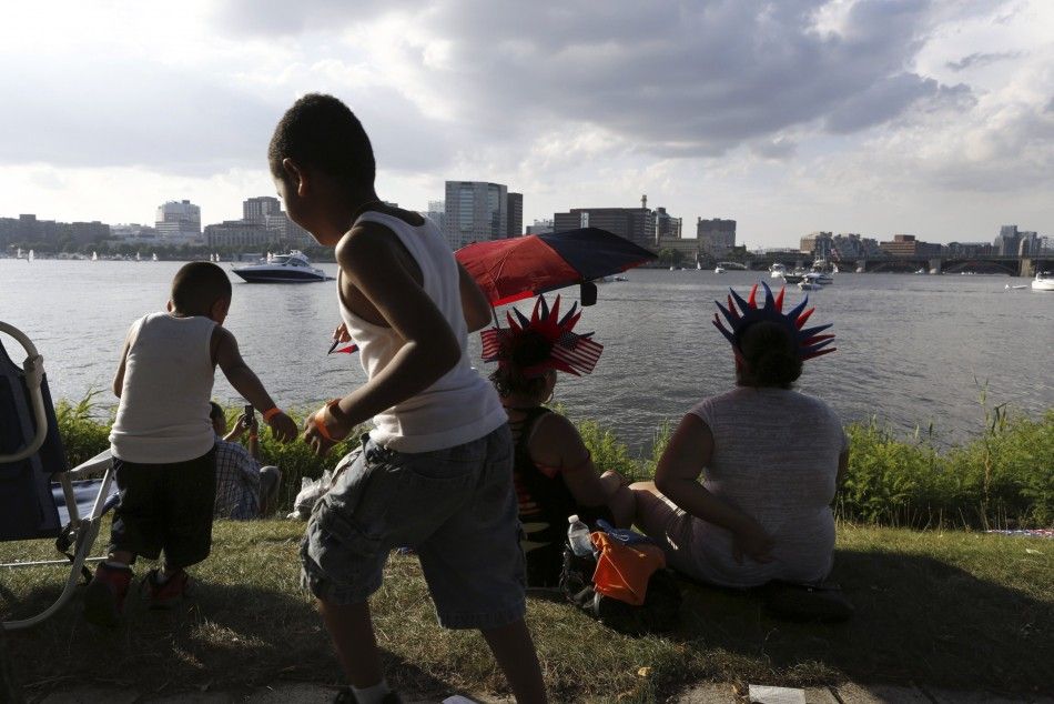 Children play on the banks of the Charles River as officials prepare to celebrate Independence Day a day early in Boston, Massachusetts July 3, 2014. The celebrations were moved for the first time since 1992 due to the developments of Hurricane Arthur on 