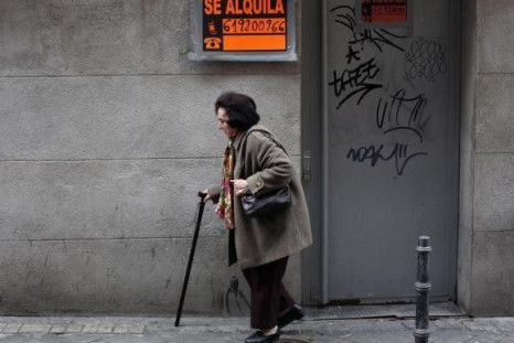 A woman walks past a closed down business in Madrid March 27, 2013.