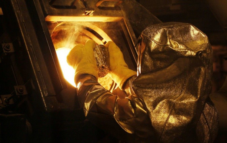 Senior refinery technician Vincente Sandoval puts a gold &quot;button&quot; into a furnace to be further refined to form gold dore bars at Newmont Mining's Carlin gold mine operation near Elko, Nevada May 21, 2014. The dore bars contain approximately