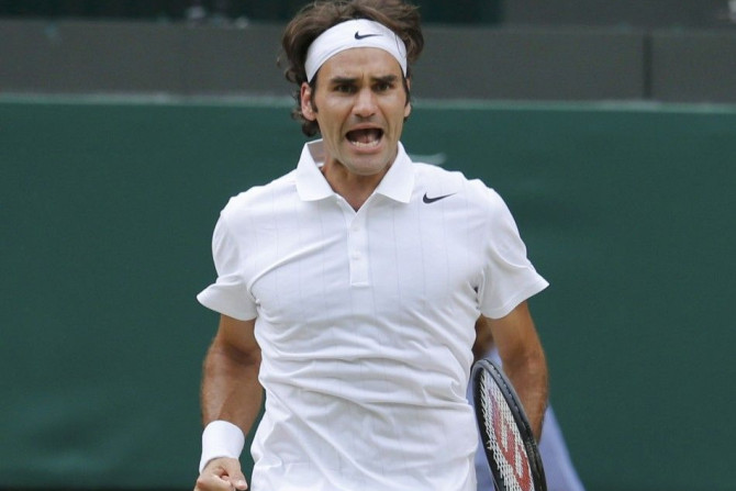 Roger Federer of Switzerland celebrates after breaking serve against Novak Djokovic of Serbia during his men's singles finals tennis match on Centre Court at the Wimbledon Tennis Championships in London July 6, 2014.