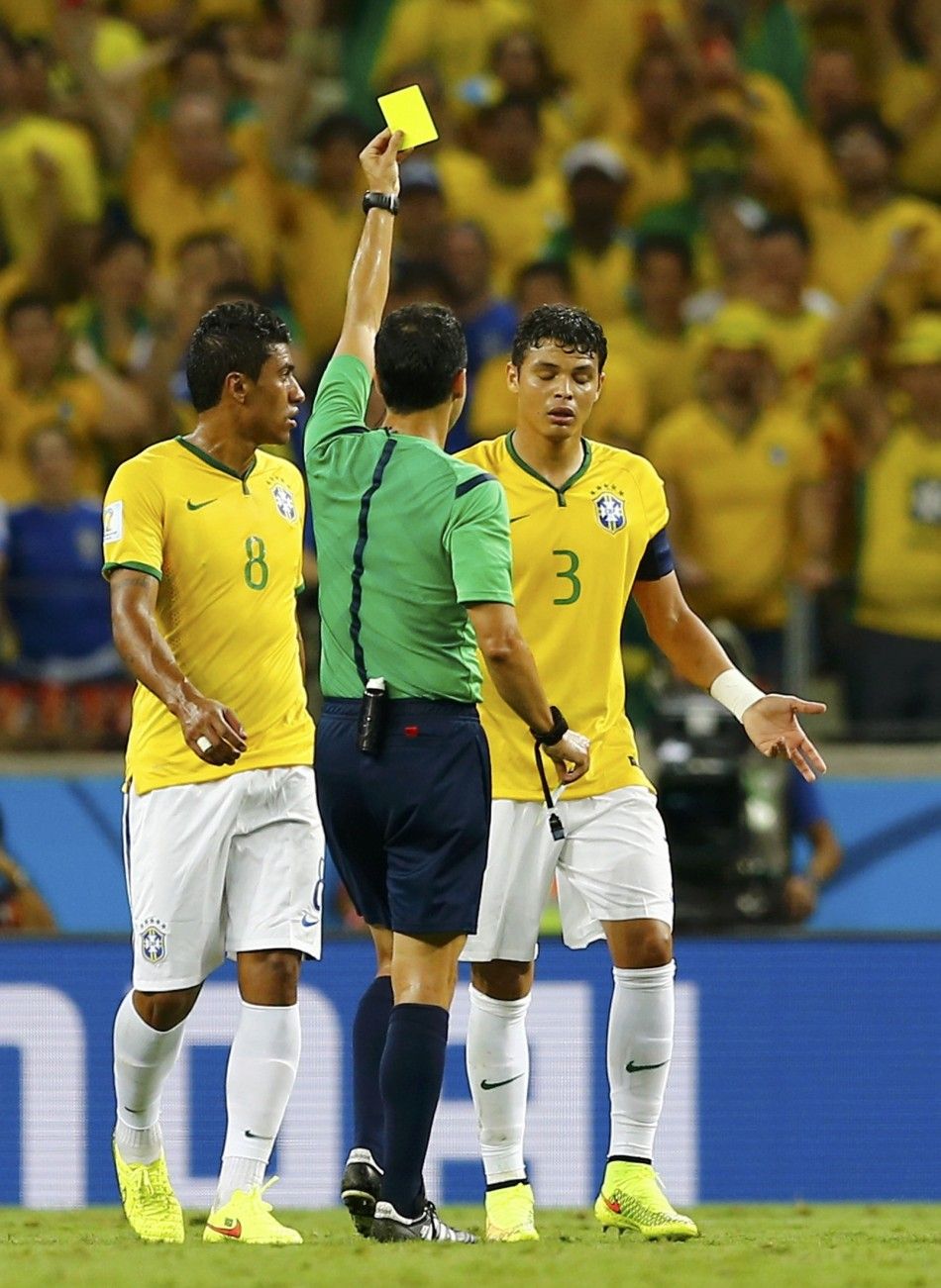Referee Carlos Velasco Carballo of Spain shows Brazils Thiago Silva the yellow card