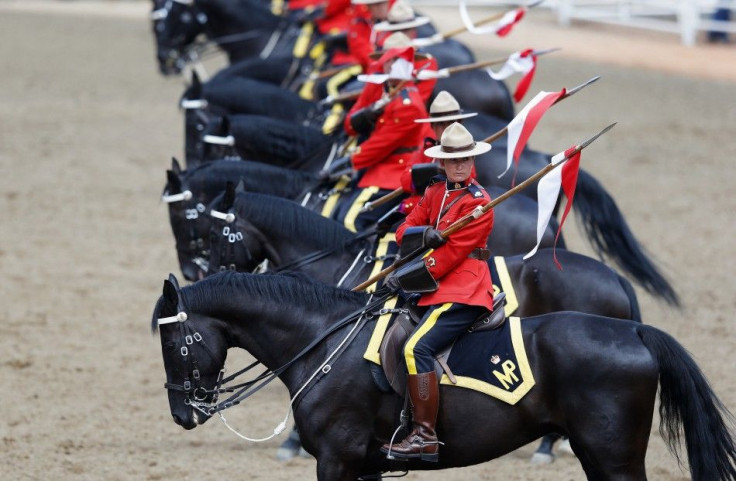 Members of the Royal Canadian Mounted Police Musical Ride demonstrate their lances during their show on day 3 of the Calgary Stampede rodeo in Calgary, Alberta, July 6, 2014. REUTERS/Todd Korol (CANADA - Tags: SPORT ANIMALS SOCIETY)