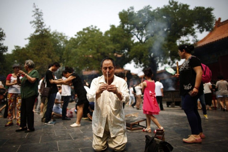 A family member of a passenger aboard the missing Malaysia Airlines flight MH370 burns incense as he prays at Yonghegong Lama Temple in Beijing June 15, 2014. Sunday marks the 100th day that the flight from Kuala Lumpur to Beijing disappeared with 239 pas