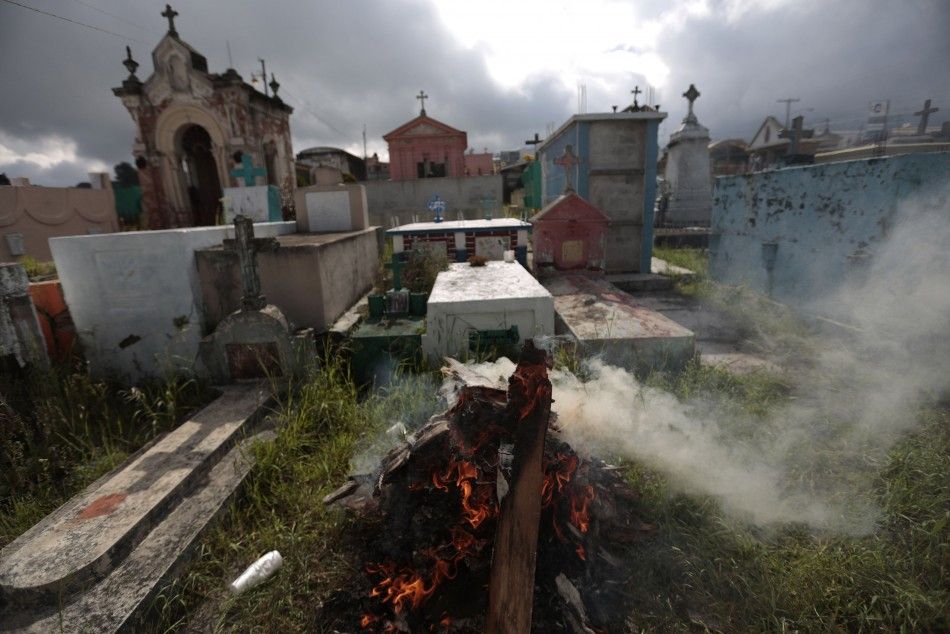 Damaged coffins are burned after the human remains in them were exhumed from destroyed graves in the cemetery of San Marcos, after an earthquake struck the San Marcos region, in northwest Guatemala, July 7, 2014. A strong earthquake shook the border betwe