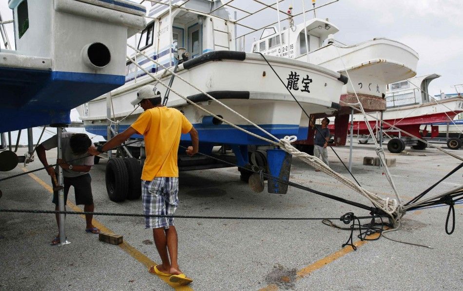 Men secure a fishing boat at a port as super typhoon Neoguri approaches the region, on Japans southern island of Miyakojima, Okinawa prefecture, in this photo taken by Kyodo July 7, 2014. Japans weather agency on Monday issued emergency warnings to urge