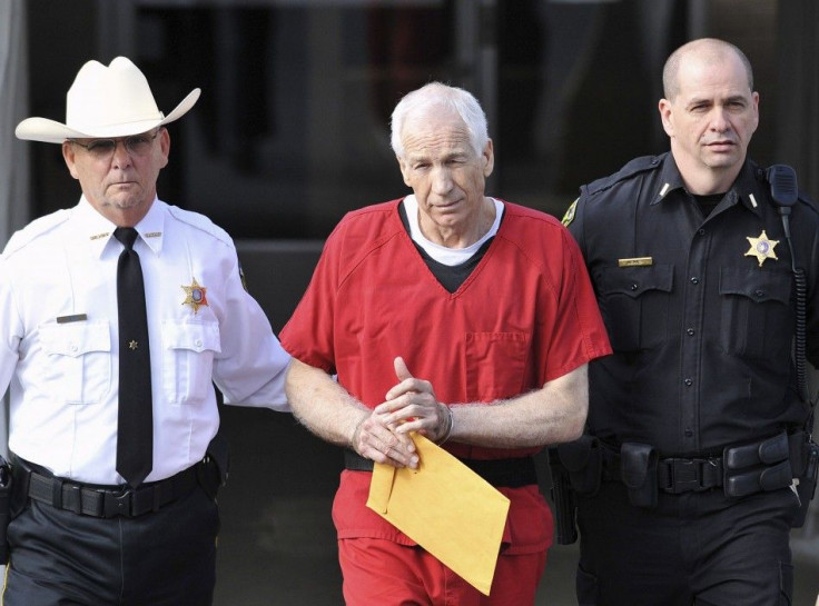Jerry Sandusky (C) leaves the Centre County Courthouse after his sentencing in his child sex abuse case in Bellefonte, Pennsylvania in this file photo from October 9, 2012. Pennsylvania's attorney general on June 23, 2014 will release the findings of