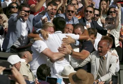 Novak Djokovic of Serbia celebrates with his coaching staff after defeating Roger Federer of Switzerland