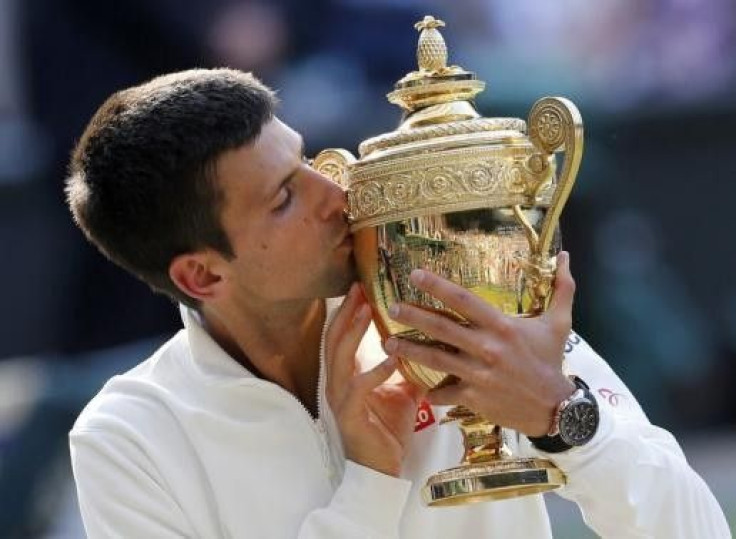 Novak Djokovic of Serbia kisses the winners trophy after defeating Roger Federer of Switzerland in their men&#039;s singles final tennis match at the Wimbledon Tennis Championships, in London July 6, 2014.