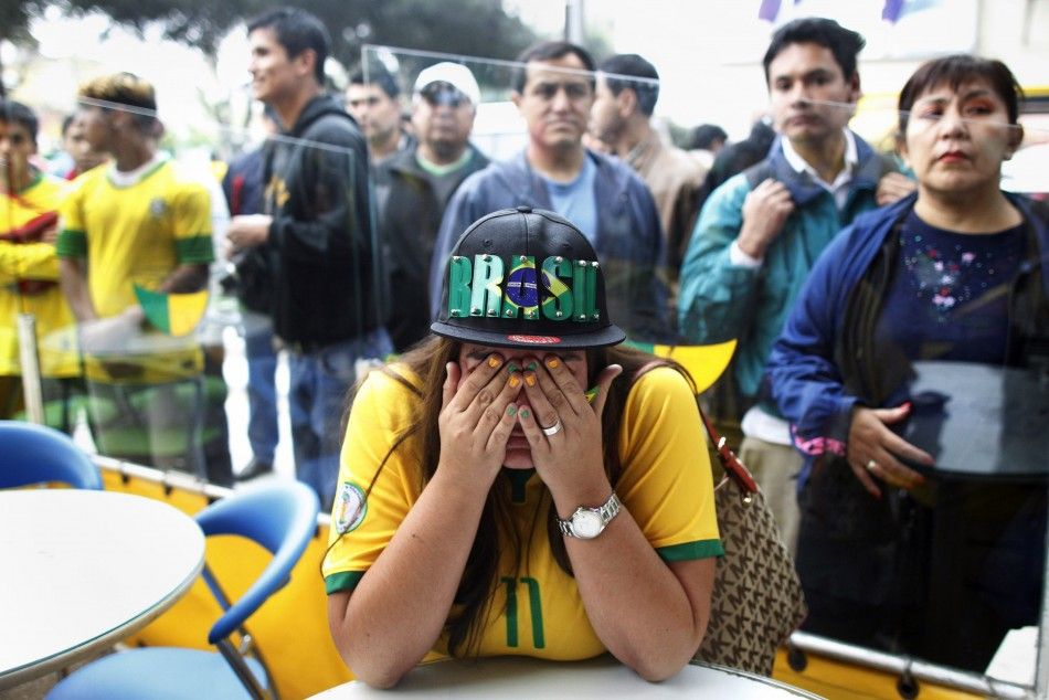 A fan reacts after watching a live broadcast match where Brazil was beaten by Germany in the 2014 World Cup semi-finals, at a Brazilian restaurant in Lima