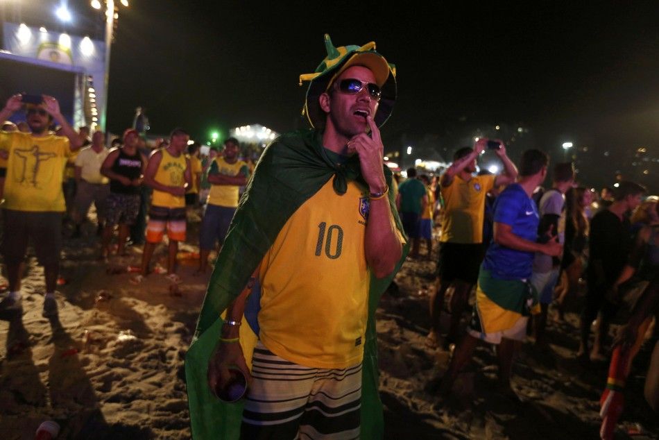 A Brazil soccer fan reacts as he watches the 2014 World Cup semi-final between Brazil and Germany at Copacabana beach in Rio de Janeiro