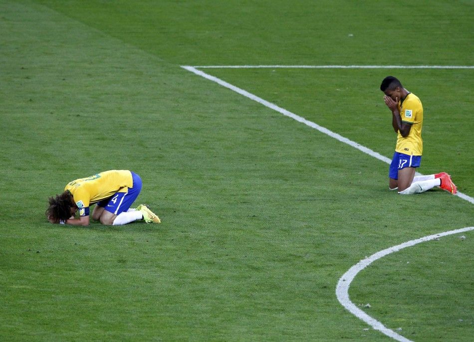 Brazils Luiz and Gustavo react after losing their 2014 World Cup semi-finals against Germany at the Mineirao stadium in Belo Horizonte