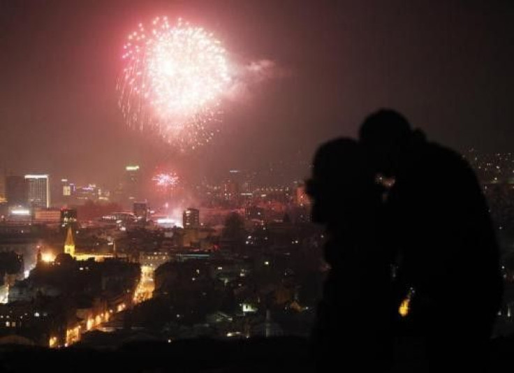 A couple kiss as fireworks light the sky during New Year celebrations in Sarajevo January 1, 2012.