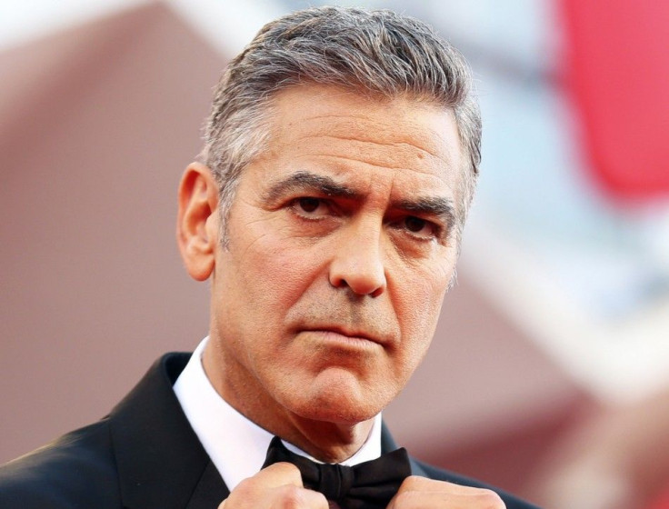 U.S. actor George Clooney adjusts his bowtie as he arrives for the premiere of &quot;Gravity&quot; at the 70th Venice Film Festival in Venice in this file photo taken August 28, 2013.