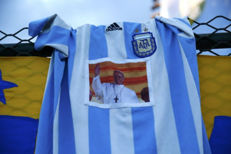 An Argentina jersey with a picture of Pope Francis is seen as fans watch the 2014 World Cup semi-final match between Argentina and the Netherlands at Copacabana beach in Rio de Janeiro, July 9, 2014.  REUTERS/Jorge Silva (BRAZIL  - Tags:  RELIGION SOCCER 