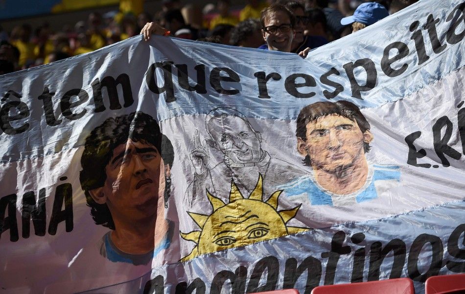 Argentina fans hold a banner with images of L-R Diego Maradona, Pope Francis and Lionel Messi before the teams 2014 World Cup quarter-finals against Belgium at the Brasilia national stadium in Brasilia July 5, 2014. REUTERSDylan Martinez BRAZIL  - Ta