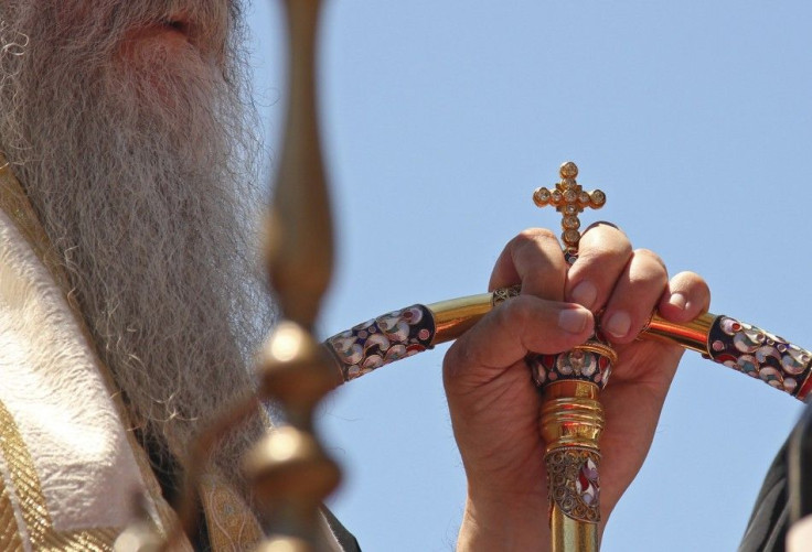 An Orthodox priest holds a cross as Serbs gather to mark the anniversary of the 1389 Battle of Kosovo at Gazimestan, near Pristina