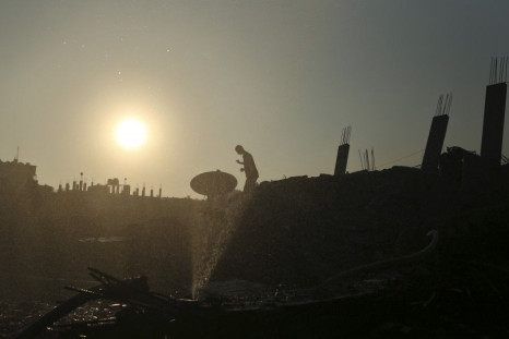 Palestinian walks atop the rubble of a house which police said was destroyed in an Israeli air strikes in Gaza City