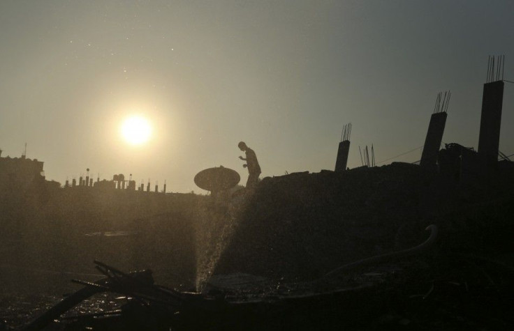 Palestinian walks atop the rubble of a house which police said was destroyed in an Israeli air strikes in Gaza City