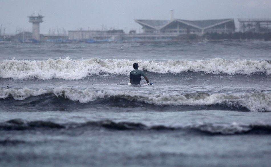 A surfer makes his way into the sea as tropical storm Neoguri approaches, at Shichirigahama beach in Kamakura, south of Tokyo July 11, 2014. Heavy rain battered a wide swathe of Japan on Thursday, sending rivers over their banks and setting off a landslid