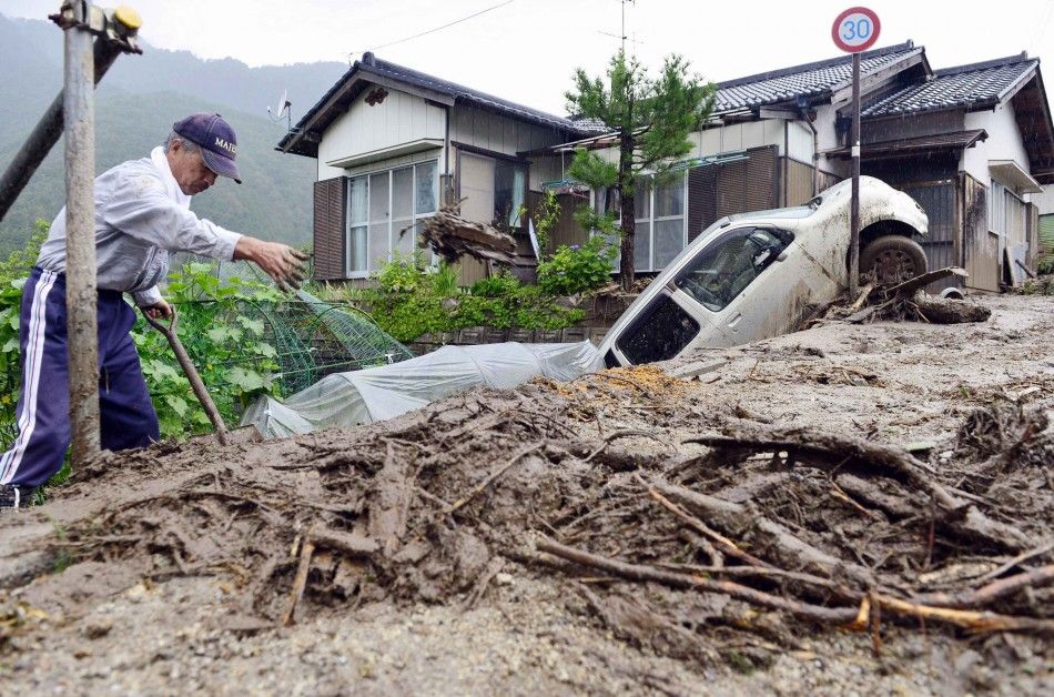 A man clears debris at an area affected by landslide caused by heavy rains due to Typhoon Neoguri in Nagiso town, Nagano prefecture, in this photo taken by Kyodo July 10, 2014. A landslide pummelled the town of Nagiso in central Japan late on Wednesday, s