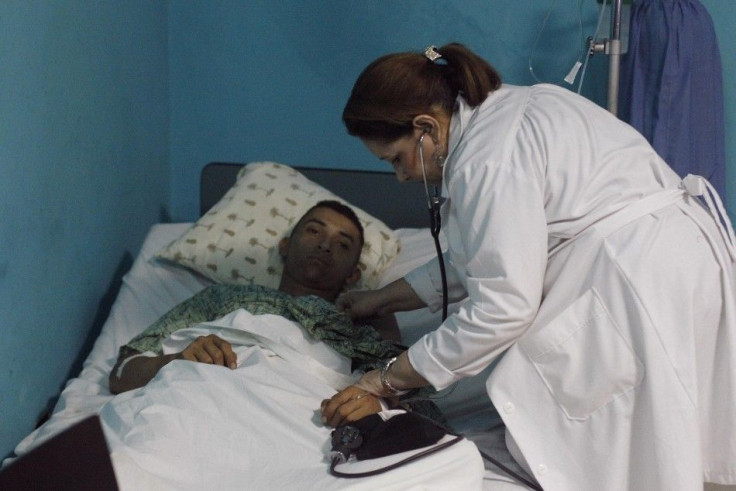 A doctor checks a miner, rescued from a gold mine affected by a landslide 