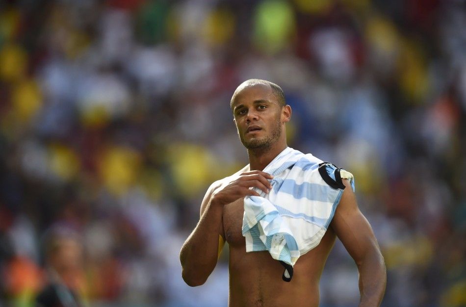 Belgiums Kompany walks off the field with an Argentina jersey on his shoulder after his teams loss at the end of their 2014 World Cup quarter-finals at the Brasilia national stadium in Brasilia